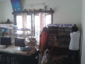 Nandhini, Sita, and Raja work together to move a bookshelf.